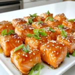 For this recipe, you need: - 1 lb fresh salmon fillet, skin removed and cut into bite-sized cubes - 1/4 cup teriyaki sauce, low-sodium recommended - 1 tablespoon honey - 1 tablespoon sesame oil - 1 teaspoon grated fresh ginger - 1 teaspoon minced garlic These ingredients blend well to create a tasty marinade. The salmon should be fresh for the best flavor and texture. You will also need: - 1 tablespoon cornstarch - Salt and pepper to taste - 1 tablespoon sesame seeds (for garnish) - 2 green onions, finely chopped (for garnish) The cornstarch gives the salmon bites a crispy outside. Salt and pepper add just the right touch to enhance the dish. If you want to boost the flavor, consider adding: - A squeeze of lime juice for brightness - Red pepper flakes for a touch of heat - A drizzle of sriracha for spice These optional ingredients can take your teriyaki salmon bites to the next level. Feel free to mix and match them based on your taste. To start, let's make the tasty marinade. In a medium bowl, mix together: - 1/4 cup teriyaki sauce (I like low-sodium for less salt) - 1 tablespoon honey - 1 tablespoon sesame oil - 1 teaspoon grated fresh ginger - 1 teaspoon minced garlic Stir these ingredients well. This blend will make your salmon flavorful and sticky. Now, we will marinate the salmon. Take 1 pound of fresh salmon fillet, skin removed, and cut it into bite-sized cubes. Add the salmon to the marinade. Toss gently to coat every piece. Cover the bowl and place it in the fridge for at least 30 minutes. This step allows the salmon to soak up all those great flavors. Once the salmon has marinated, it’s time to cook. First, sprinkle 1 tablespoon of cornstarch over the salmon cubes. Toss them gently to coat evenly. This will help create a crispy outside. Now, preheat your air fryer to 375°F (190°C) for about 3-5 minutes. When it's ready, place the salmon bites in a single layer in the basket. Don’t crowd them! This helps them cook evenly. Air fry the salmon for 8-10 minutes. Flip them halfway through for even cooking. The bites should be golden and crispy. Make sure the internal temperature reaches 145°F (63°C). When done, remove the salmon from the air fryer. Season with a little salt and pepper. Transfer to a serving platter and garnish with sesame seeds and chopped green onions. Enjoy your delicious crispy teriyaki salmon bites! To get the best crispy salmon bites, coat each piece with cornstarch. This step is key. Cornstarch creates a crunchy layer that makes the bites extra delicious. Make sure you toss the salmon gently but well. This ensures even coverage. For perfect salmon bites, preheat your air fryer to 375°F (190°C). Cook the salmon for about 8-10 minutes. Flip the bites halfway through to ensure they cook evenly. Check that the internal temperature reaches 145°F (63°C). This means the salmon is safe to eat and perfectly cooked. One common mistake is overcrowding the air fryer. Make sure to place the salmon in a single layer. This helps them cook evenly and stay crispy. Another mistake is not marinating long enough. The salmon needs at least 30 minutes in the marinade to soak up all the flavors. {{image_2}} You can switch up the marinade to add new flavors. Try a honey mustard blend. Mix equal parts honey and Dijon mustard. Add a splash of lemon juice for a bright twist. A soy sauce and lime mix works well too. This gives a tangy taste that pairs nicely with salmon. You can even try a spicy sriracha and maple syrup mix for heat. Salmon is tasty, but other proteins can work too. Chicken breast bites can be a great option. Cut the chicken into small cubes and follow the same steps. Shrimp is another fun choice. Just adjust the cooking time, as shrimp cooks faster than salmon. Tofu is perfect for a vegetarian twist. Use firm tofu, and marinate it like the salmon. Serve your salmon bites over rice or quinoa for a hearty meal. Add some steamed broccoli or snap peas for color and crunch. You can also make a fresh salad with mixed greens and a light vinaigrette. For a fun twist, serve the bites in lettuce wraps. Garnish with extra sesame seeds and green onions for that fancy touch. To store your leftover salmon bites, let them cool first. Place them in an airtight container. Keep the container in the fridge. Try to eat them within two days for the best taste. To reheat, use your air fryer. Set it to 350°F (175°C). Heat the salmon bites for about 5 minutes. This method keeps them crispy. You can also use a microwave, but they may not be as crunchy. If you want to freeze salmon bites, let them cool completely. Place them in a freezer-safe bag. Remove as much air as possible before sealing. They can last up to three months in the freezer. When ready to eat, thaw in the fridge overnight, then reheat as mentioned. Yes, you can use frozen salmon. Just make sure to thaw it completely first. This helps the marinade soak in well. After thawing, cut it into bite-sized cubes. The rest of the steps remain the same. If you don't have teriyaki sauce, try soy sauce mixed with honey. You can also use a mix of soy sauce, brown sugar, and a little rice vinegar. This gives a similar sweet and salty flavor. Adjust the amount based on your taste. The salmon is done when it reaches an internal temperature of 145°F (63°C). You can check this with a food thermometer. The color should change from bright pink to a light pink and opaque. Yes, you can bake the salmon bites in an oven. Preheat your oven to 400°F (200°C). Spread the salmon on a baking sheet lined with parchment paper. Bake for about 12-15 minutes, flipping halfway through. This will also give you crispy bites! This blog post covered how to make delicious air-fried salmon bites. We explored the essential ingredients, from fresh salmon to seasoning options. I shared step-by-step instructions for marinating and cooking. Tips on crispiness and common mistakes help for great results. I also suggested variations and storage advice to keep your salmon fresh. Remember, experimenting with flavors and adjustments can make this recipe your own. Enjoy your cooking journey and savor every bite!