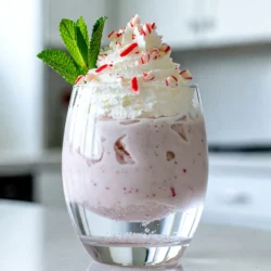 To make a Peppermint Christmas Float, gather these simple ingredients: - 2 cups peppermint ice cream - 1 cup milk (whole or almond) - 1 cup sparkling water or lemon-lime soda - 1 teaspoon vanilla extract - 1/4 teaspoon peppermint extract - Whipped cream for topping - Crushed candy canes for garnish - Fresh mint leaves for decoration Each ingredient adds a special touch. The peppermint ice cream gives a creamy, minty flavor. The milk helps blend everything. You can choose whole milk for richness or almond milk for a lighter option. Sparkling water or soda adds a fizzy kick. The vanilla extract enhances the sweetness. The peppermint extract boosts the minty taste. Whipped cream makes it extra festive. Crushed candy canes add crunch and color. Fresh mint leaves give a lovely finish. Gather everything and get ready for a fun treat! {{ingredient_image_1}} - Step 1: Blend the ice cream and liquids Start by adding 2 cups of peppermint ice cream to your blender. Pour in 1 cup of milk, either whole or almond. Add 1 teaspoon of vanilla extract and 1/4 teaspoon of peppermint extract. Blend these together until smooth and creamy. This mix should look rich and delicious. - Step 2: Pour sparkling water or soda Grab your serving glasses or mugs. Carefully pour in 1 cup of sparkling water or lemon-lime soda. Fill each glass halfway. This step adds a nice fizz to your float. - Step 3: Add the ice cream mixture Now, take your blended ice cream mixture. Spoon it gently on top of the sparkling water in each glass. Aim to fill each glass to the brim. The layers should look pretty and inviting. - Step 4: Top with whipped cream Next, take some whipped cream. Add a generous dollop on top of each float. This adds a layer of creaminess that pairs perfectly with the peppermint. - Step 5: Garnish with candy canes and mint leaves Finally, sprinkle crushed candy canes on top of the whipped cream. Add a fresh mint leaf for a pop of color. These garnishes make your float festive and fun. Serve your Peppermint Christmas Float right away. Use a long spoon or straw to mix the layers as you enjoy. To make the perfect Peppermint Christmas Float, you need the right blend. Start by adding the peppermint ice cream, milk, vanilla extract, and peppermint extract into your blender. Blend until it becomes smooth and creamy. If the mix is too thick, add a little more milk. You want it to pour easily. You can use different appliances for blending. A regular blender works great. If you want a finer texture, try an immersion blender. Just blend it right in the mixing cup. This makes cleaning up easy! Presentation matters! Choose tall glasses or festive mugs for your floats. Clear glass lets the layers shine through. You can also use mason jars for a fun twist. Pair this float with holiday treats. Cookies, brownies, or even fruitcake make great options. The sweet taste of peppermint blends well with many flavors. Serve them on a pretty tray to impress your guests! Pro Tips Use Chilled Ingredients: Ensure that your milk and sparkling water are chilled before mixing to keep the float refreshing and cool. Experiment with Flavors: Try different ice cream flavors like vanilla or chocolate for a unique twist on this classic float. Layering Technique: Pour the sparkling water slowly to maintain the layers and prevent the ice cream from sinking too quickly. Garnish Creatively: Besides crushed candy canes, consider adding colorful sprinkles or chocolate shavings for an extra festive touch. {{image_2}} You can mix up the peppermint Christmas float by using different ice cream flavors. Try chocolate or vanilla ice cream for a twist. These flavors add richness, making the drink even more fun. You can also use non-dairy alternatives. Almond or coconut milk works well. For ice cream, coconut or almond milk ice cream is a great choice for those with dairy needs. Make your float look festive with fun garnishes. Add sprinkles, mini marshmallows, or chocolate shavings. Each of these can bring a pop of color. You can also use creative glass ideas. Use holiday mugs or clear cups to show off the layers. You can even use mason jars for a rustic feel. To store the leftover ice cream mixture, pour it into an airtight container. Seal it tightly. Place the container in the freezer. This helps keep the flavors fresh and the texture smooth. If you have extra whipped cream, store it in a separate bowl, covered with plastic wrap. This keeps it fluffy. You can prepare the peppermint Christmas float ahead of time for holiday fun. Make the ice cream mixture up to two days in advance. Just blend the ice cream, milk, and extracts as usual. Then, store it in the freezer. When ready to serve, just pour the sparkling water or soda in glasses and add the ice cream mixture. This saves time on busy days. Can I use regular soda instead of sparkling water? Yes, you can use regular soda. Lemon-lime soda works well. It adds sweetness and flavor. Just keep in mind it will change the taste. If you want a lighter drink, stick with sparkling water. Is it possible to make this float in advance? I don't recommend making it too early. The ice cream will melt, and the drink will lose its fizz. However, you can prepare the ice cream mixture ahead. Just store it in the fridge and mix it when you’re ready. What can I substitute if I don't have peppermint ice cream? You can use vanilla ice cream or chocolate ice cream. These flavors still taste great with the peppermint extracts. You can also try other mint-flavored ice creams for a fun twist. How to make a non-alcoholic version for kids? This recipe is already non-alcoholic! Just follow the steps and enjoy. Kids will love the fun colors and flavors. You can add fun straws or colorful cups for extra excitement. This post showed how to make a fun peppermint float. You learned the ingredients, steps, and tips to create it perfectly. We explored different flavors and how to present it well. You can store any leftovers for later enjoyment. With these details, you can impress your friends and family during the holidays. Enjoy experimenting with this recipe and make it your own! This peppermint float will be a highlight at any festive gathering.