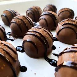 To make these tasty Keto Chocolate Peanut Butter Fat Bombs, you need: - 1 cup natural peanut butter (unsweetened) - 1/2 cup coconut oil, melted - 1/4 cup unsweetened cocoa powder - 1/4 cup erythritol or stevia, adjusted to taste - 1 teaspoon vanilla extract - Pinch of salt - Optional: Chopped nuts or sugar-free chocolate chips You can adjust the recipe for different diets. If you want a nut-free option, use sunbutter instead of peanut butter. For a dairy-free version, ensure your sweetener is dairy-free. You can swap coconut oil with avocado oil if you prefer. If you do not like erythritol, try monk fruit sweetener. These fat bombs are rich in healthy fats. Each serving has about 100 calories. They provide about 9 grams of fat and 2 grams of net carbs. This makes them a great snack for a keto diet. They help keep you full and give you energy. Enjoy them when you need a sweet treat without the carbs! {{ingredient_image_1}} Start by gathering your ingredients. You need natural peanut butter, melted coconut oil, unsweetened cocoa powder, erythritol or stevia, vanilla extract, and a pinch of salt. In a medium mixing bowl, combine the melted coconut oil and peanut butter. Mix these two well until they blend smoothly. This step is key for a nice texture. Next, add the unsweetened cocoa powder, erythritol, vanilla extract, and salt. Stir continuously until the mixture becomes creamy and smooth. If you want, fold in chopped nuts or sugar-free chocolate chips for extra crunch and flavor. Now it's time to mold your mixture. Grab a mini muffin tin or silicone molds. If you like, line them with parchment paper to make removal easier later. Pour the creamy mixture into the molds, filling each about three-quarters full. This helps them hold their shape when frozen. Be sure to fill them evenly so they freeze at the same rate. Place your filled molds in the freezer. Let them freeze for about 30 to 40 minutes. Check to see if they are firm to the touch; this means they are ready. Once firm, carefully remove the fat bombs from the molds. Store them in an airtight container. You can keep them in the refrigerator or the freezer. This way, they'll stay fresh and tasty for when you need a quick snack or treat. To get the best texture for your fat bombs, mix well. Use smooth, natural peanut butter. The coconut oil must be melted but not hot. This helps blend everything easily. Stir until the mix is smooth and creamy. If you add nuts or chocolate chips, fold them in gently. This keeps your fat bombs from being too dense. Sweetness is key to a great taste. Start with 1/4 cup of erythritol or stevia. Taste the mix. If you want it sweeter, add more. Just remember, sweeteners can vary in strength. Adjust it slowly so you get your perfect flavor. You can also try different sweeteners to find what you love best. You can make these fat bombs ahead of time. Once they are firm, store them in an airtight container. They last well in the fridge for about a week. For longer storage, keep them in the freezer. Just take out what you need, and they are ready to eat. Enjoy a tasty treat anytime! Pro Tips Quality Ingredients: Use high-quality, natural peanut butter for the best flavor and texture. Avoid brands with added sugars or oils. Adjust Sweetness: Taste the mixture before pouring it into molds; adjust the sweetness with erythritol or stevia to suit your preference. Texture Variations: Experiment with different add-ins like shredded coconut or dried berries to change the flavor profile and texture of your fat bombs. Storage Tips: Store the fat bombs in an airtight container in the refrigerator for up to two weeks or in the freezer for longer shelf life. {{image_2}} You can change the taste of your fat bombs easily. Add a tablespoon of instant coffee for a mocha twist. Want a fruity touch? Mix in a few drops of orange or peppermint extract. You can also add spices like cinnamon or nutmeg for warmth. Feel free to get creative with flavors you love! If you need nut-free options, use sunbutter or pumpkin seed butter instead of peanut butter. Both work well and keep the fat bomb creamy. You can also try tahini, which gives a unique flavor. These options keep your recipe tasty and safe for those with nut allergies. For a lower-carb chocolate taste, use cacao nibs instead of cocoa powder. They add a crunchy texture and rich flavor. You can also opt for sugar-free dark chocolate. Melt it and drizzle over the top for a fancy touch. These swaps keep your fat bombs delicious and keto-friendly. Keto fat bombs are a great snack for people on a ketogenic diet. They help you stay in ketosis by providing healthy fats without carbs. These fat bombs have a low-carb count, which supports your body's fat-burning state. You can enjoy them without guilt, knowing they fit your meal plan. When you need a quick snack, fat bombs are perfect. They are easy to grab and tasty. Pair them with a cup of coffee or tea for a delightful treat. You can also serve them at parties as a sweet surprise. They can even satisfy your sweet tooth without breaking your diet. Fat bombs provide healthy fats that give you energy. They help keep you full, so you won’t feel hungry soon after eating. This makes them a smart choice for busy days. The mix of peanut butter and coconut oil in these fat bombs is both tasty and nutritious. Enjoying fats can make you feel good while following your diet. Keto chocolate peanut butter fat bombs can last up to two weeks in the fridge. Store them in an airtight container to keep them fresh. If you freeze them, they can last for about three months. Just make sure to thaw them in the fridge before eating. Yes, you can use natural sweeteners like stevia or monk fruit. These sweeteners are low in carbs and work well in this recipe. You may need to adjust the amount to get the right sweetness level. Taste as you go to find what you like best. Fat bombs pair great with coffee or tea. The rich flavors complement each other nicely. You can also enjoy them with fresh berries for a fruity touch. If you like crunch, try them with nuts or seeds. These pairings make for a fun and tasty snack. In this post, we explored how to make keto fat bombs, from ingredients to storage tips. You learned about different substitutions and how to adjust sweetness to fit your needs. I also shared ways to enhance flavors and make nut-free or low-carb options. Keto fat bombs can be a great snack for energy and fullness. With these tips, you can enjoy tasty treats that fit a healthy diet. Get creative, and have fun while making them!